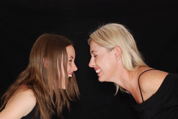 Two women laughing together. 