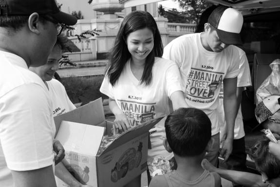 Volunteers passing out snacks to children. 
