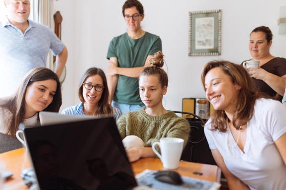 Group of people looking at one computer screen.
