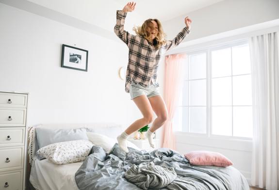 Woman jumping on bed. 
